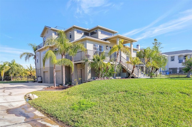 view of front of house featuring a garage, concrete driveway, a front yard, and fence