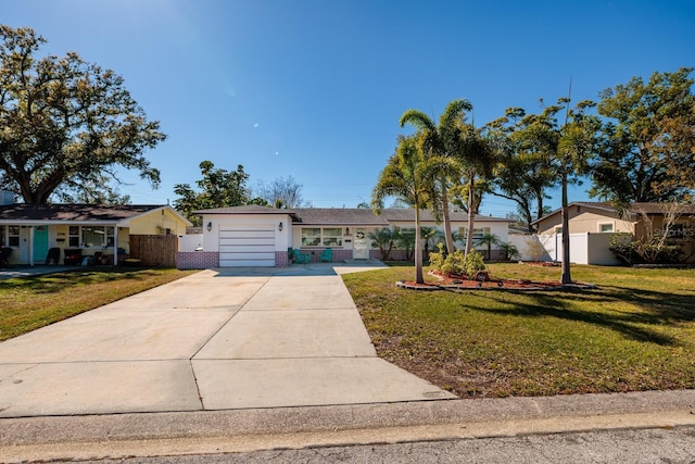 ranch-style house featuring driveway, fence, a front yard, a garage, and brick siding