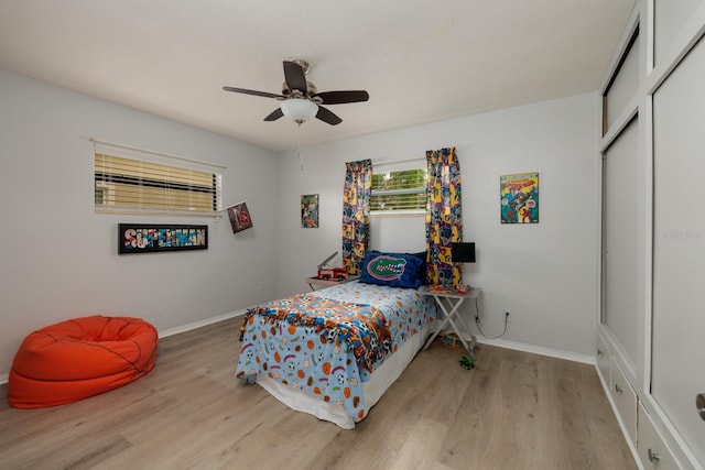 bedroom featuring a closet, ceiling fan, baseboards, and wood finished floors