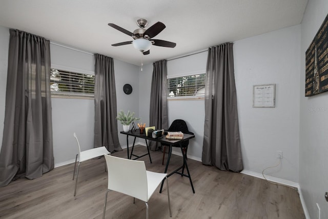 office with a ceiling fan, wood finished floors, and baseboards