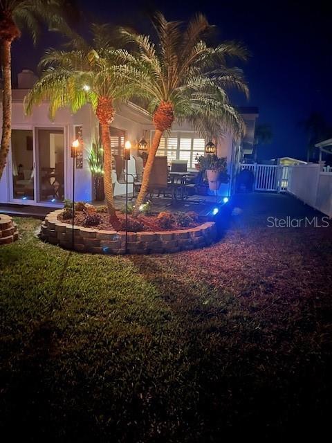 yard at night with a patio area