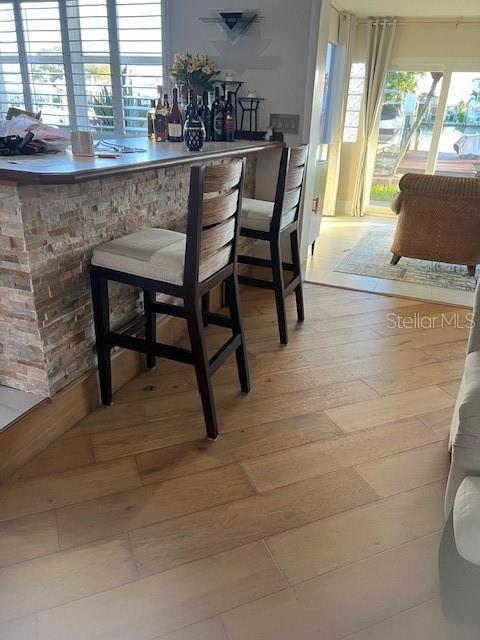 bar with a wealth of natural light and wood-type flooring