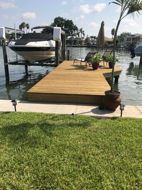 dock area featuring a water view and a lawn