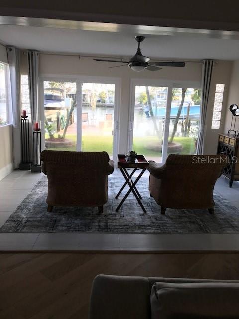 living room with a water view and ceiling fan