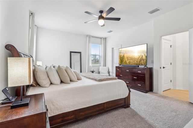 bedroom with visible vents, ceiling fan, and light carpet