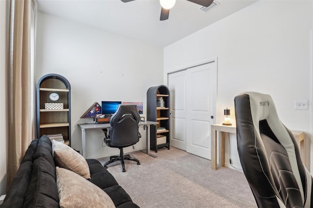 office space featuring light carpet, ceiling fan, visible vents, and baseboards