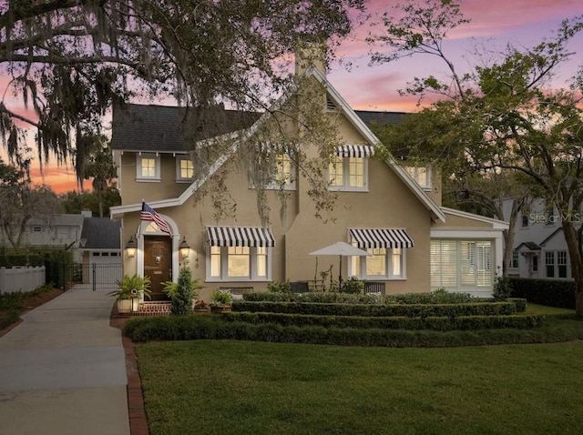 view of front facade with driveway, a front yard, and stucco siding