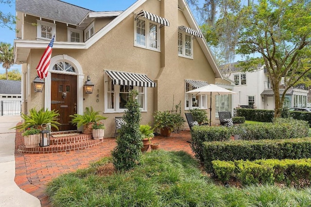 view of front of property with a shingled roof and stucco siding