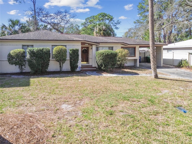 ranch-style house featuring a front lawn and a carport