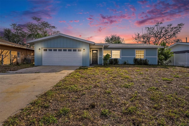 ranch-style home featuring a garage, fence, and concrete driveway