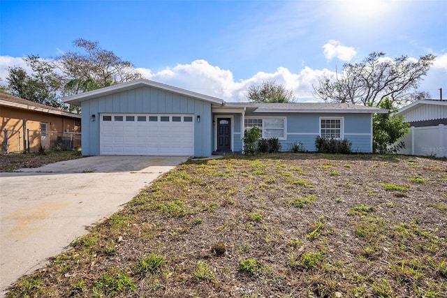 ranch-style house featuring fence, driveway, and an attached garage