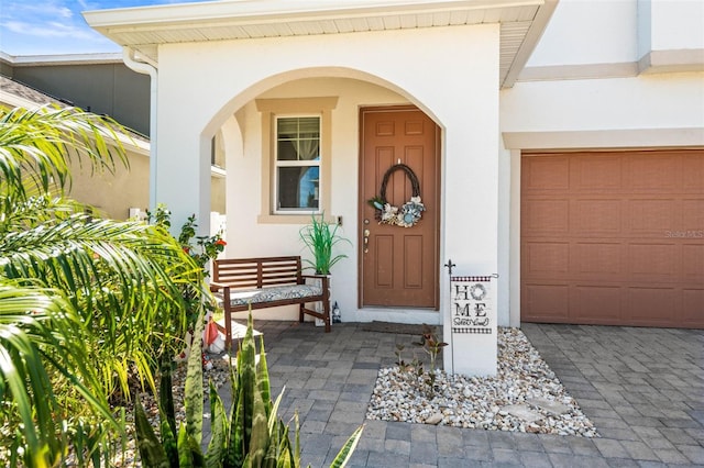 property entrance with stucco siding and a garage