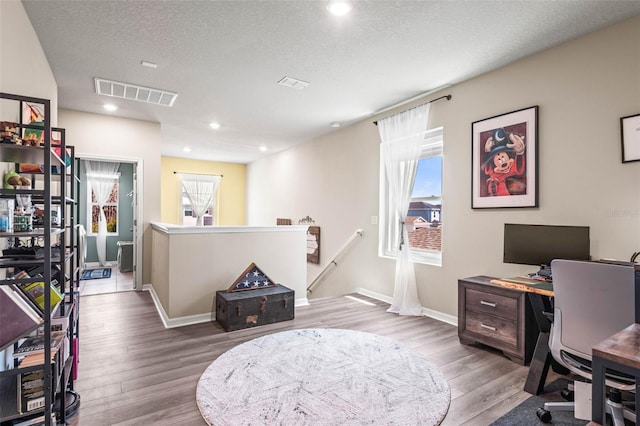 office space with wood finished floors, baseboards, visible vents, recessed lighting, and a textured ceiling