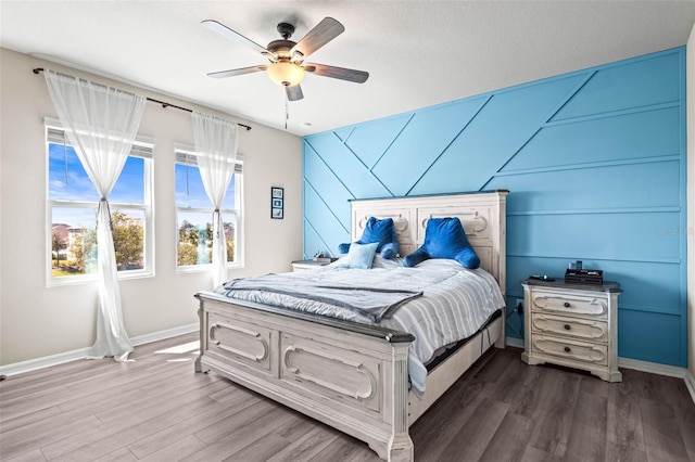 bedroom with baseboards, dark wood finished floors, and a ceiling fan