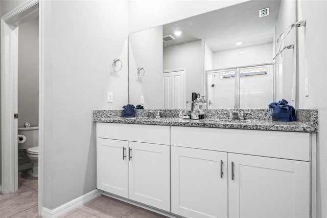 bathroom featuring visible vents, toilet, a shower stall, tile patterned flooring, and double vanity