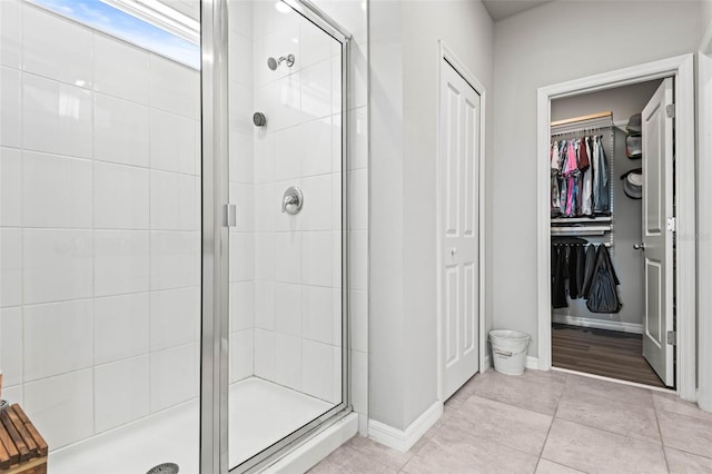 full bath featuring a shower stall, baseboards, and tile patterned floors