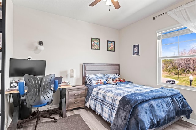 bedroom with a ceiling fan, baseboards, and wood finished floors