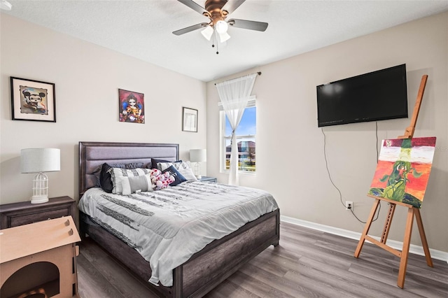 bedroom featuring a ceiling fan, wood finished floors, and baseboards