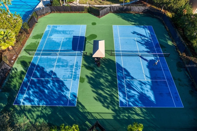 view of tennis court featuring fence