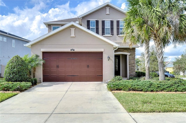 traditional-style house featuring stucco siding, a garage, and concrete driveway