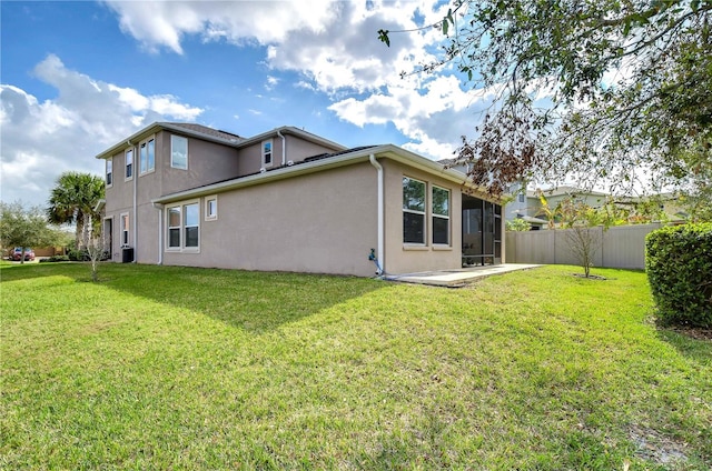 back of property with stucco siding, central AC, fence, a patio area, and a yard