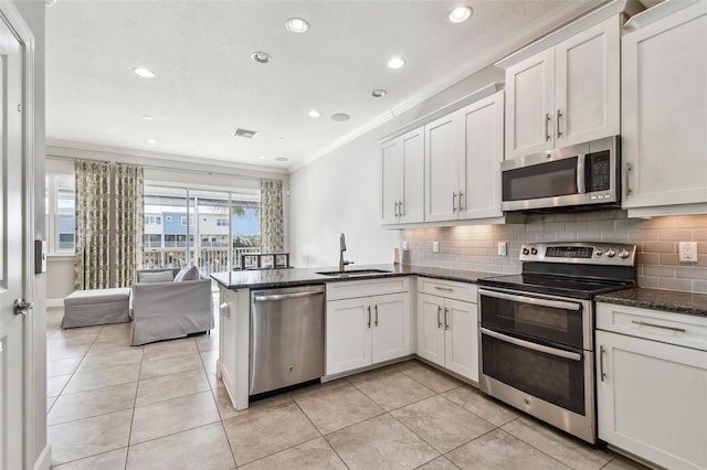 kitchen featuring white cabinets, kitchen peninsula, stainless steel appliances, and sink