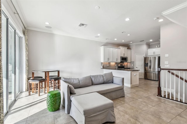 tiled living room with crown molding and sink