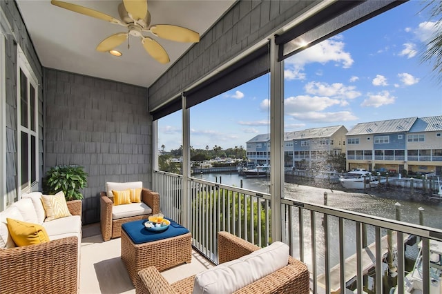 balcony with a water view, outdoor lounge area, and ceiling fan