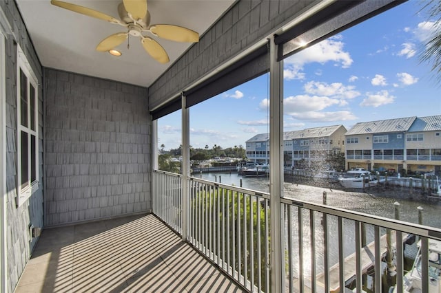 balcony with a water view and ceiling fan