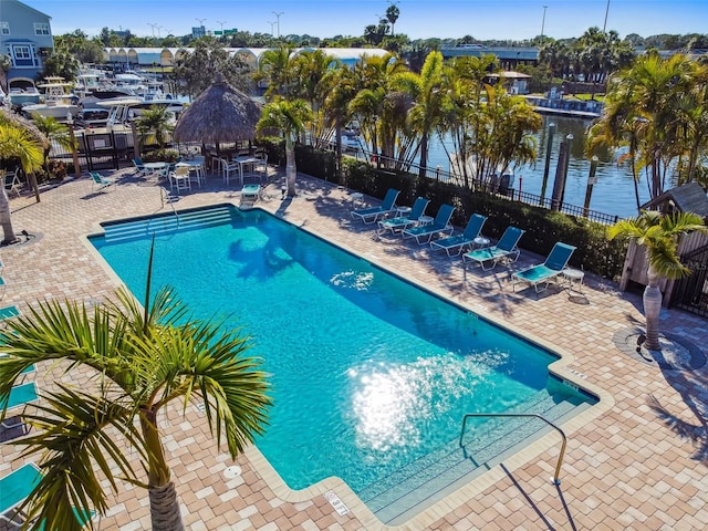 view of swimming pool featuring a water view, a patio area, and a gazebo