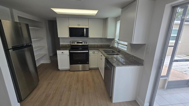 kitchen featuring light hardwood / wood-style flooring, tasteful backsplash, stainless steel appliances, sink, and white cabinetry