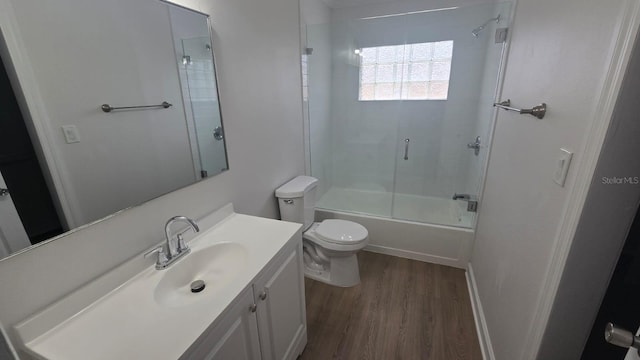 full bathroom with toilet, hardwood / wood-style flooring, shower / bath combination with glass door, and vanity