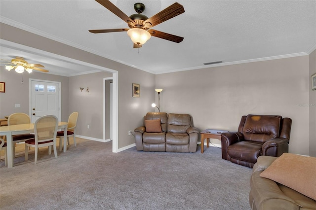 living area with ornamental molding, carpet, visible vents, and baseboards