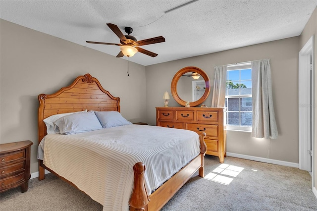 bedroom featuring ceiling fan, baseboards, and light colored carpet