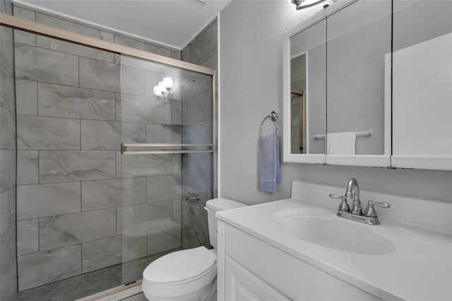full bath featuring vanity, a shower stall, and toilet