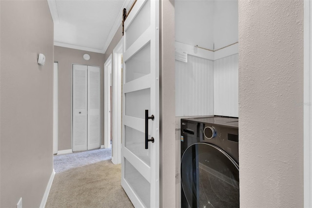 laundry room with a barn door, laundry area, carpet flooring, ornamental molding, and washer / dryer