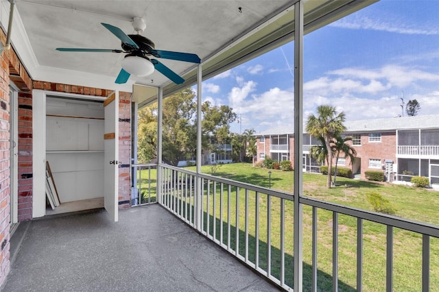 unfurnished sunroom featuring a ceiling fan and a residential view