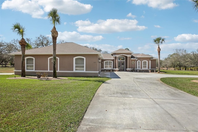 view of front facade featuring concrete driveway, a front yard, and stucco siding