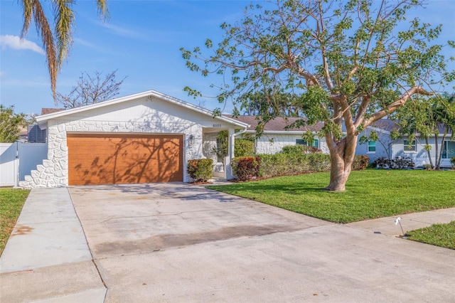 single story home with an attached garage, fence, a front lawn, stone siding, and concrete driveway