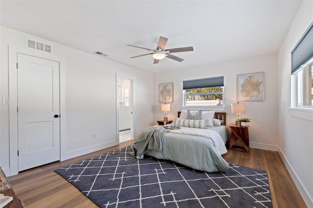 bedroom with dark wood finished floors, visible vents, and multiple windows