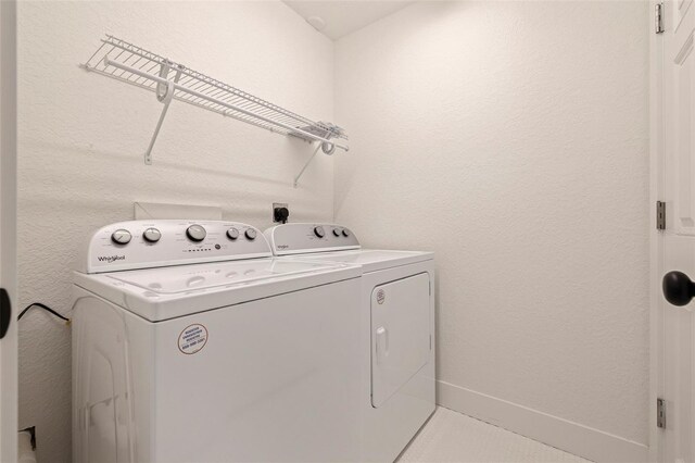 laundry room with laundry area, independent washer and dryer, and baseboards