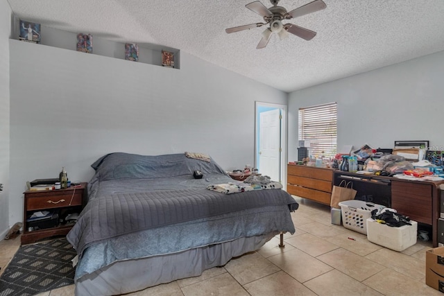 tiled bedroom with ceiling fan, vaulted ceiling, and a textured ceiling