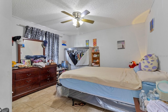 tiled bedroom with ceiling fan and a textured ceiling