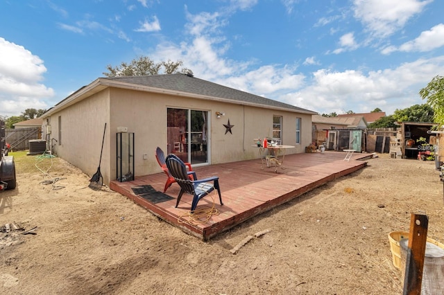 back of property featuring central AC unit, a shed, and a wooden deck