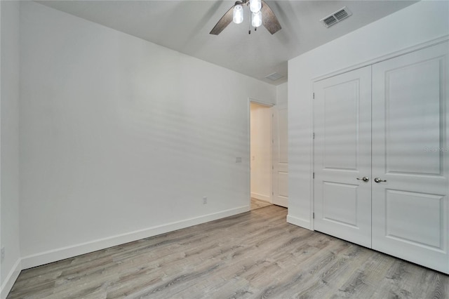 unfurnished bedroom featuring ceiling fan, light hardwood / wood-style flooring, and a closet