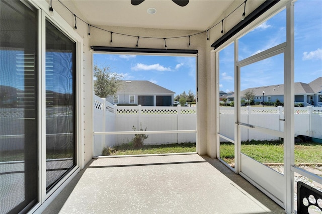 unfurnished sunroom with ceiling fan