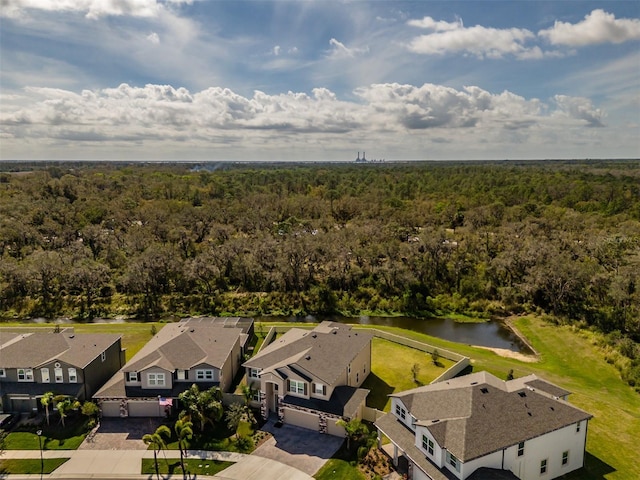 drone / aerial view featuring a residential view, a water view, and a wooded view