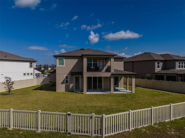 back of property with a yard, a patio, stucco siding, a residential view, and a fenced backyard
