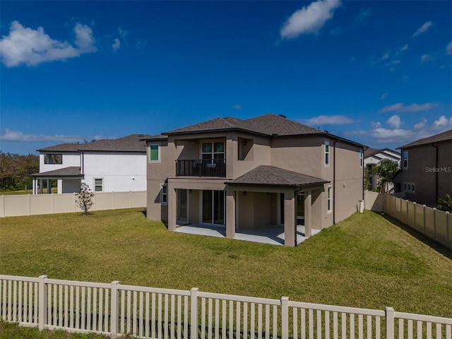 back of property featuring a balcony, a patio area, a fenced backyard, and stucco siding