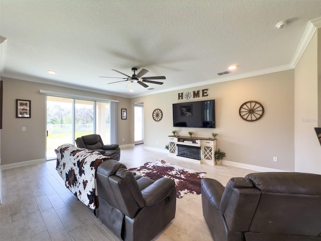 living room featuring a textured ceiling, ornamental molding, visible vents, and baseboards